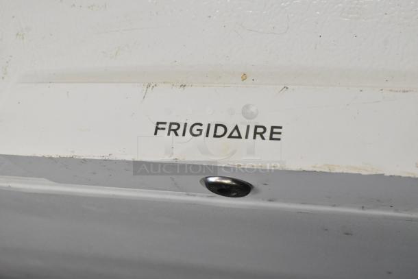 Frigidaire FFFC18M4RWA chest freezer with hinge lid, 115 volts, 1 phase, showing brand logo on white surface with some wear.