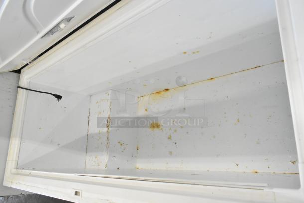 Frigidaire FFFC18M4RWA chest freezer with hinge lid, 115 volts, interior showing signs of rust and wear.