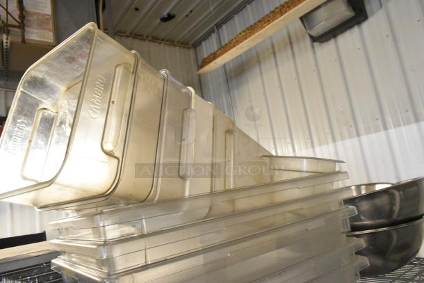 Lot of clear poly Cambro bins and stainless steel bowls, stacked on a shelf. Bins are marked "Cambro." Good condition.