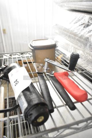 Lot of kitchen items including can opener, chef knife, Toastmaster immersion blender base, and poly bin on metal rack.