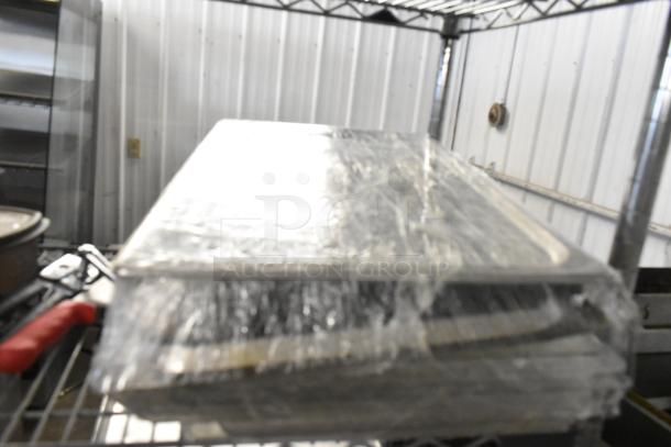 Lot of 3 poly clear lids in plastic wrap, stacked on shelving. Appears in good condition. Ideal for kitchen storage.