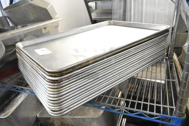 Stack of 16 full-size metal baking pans on a shelf, showing some wear. Includes label with auction information.