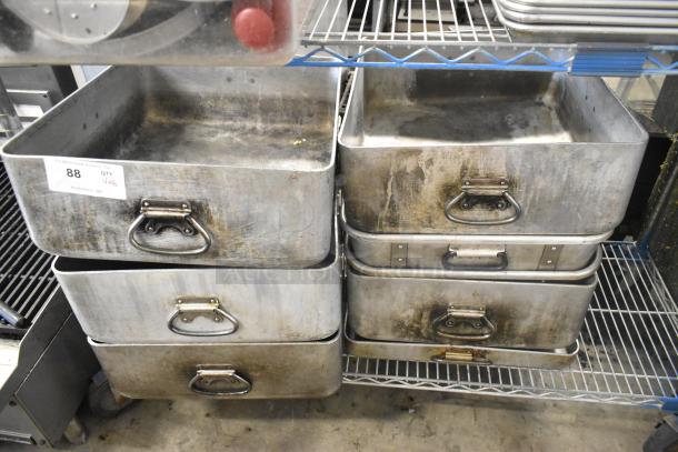 Eight large metal pans with handles, showing signs of wear and aging. Auction label indicates 8 times your bid.