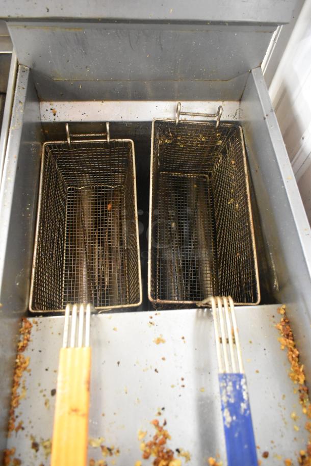 Cecilware Pro stainless steel gas fryer with two metal fry baskets, showing signs of use, ideal for commercial kitchens.