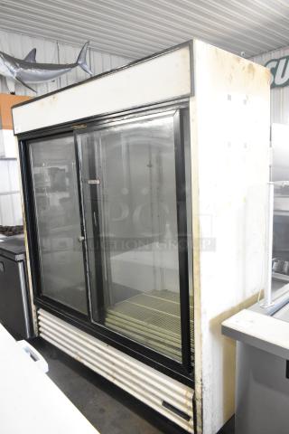 True GDM-61 two-door metal reach-in cooler merchandiser on casters, 115V, 1 phase. Visible wear, glass doors, and black trim.