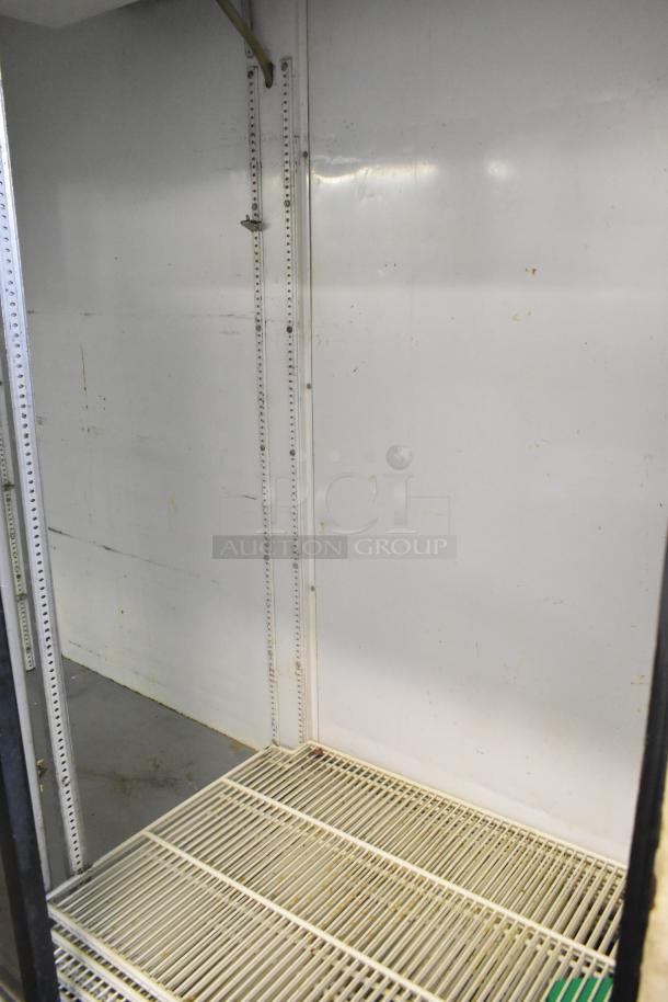 True GDM-61 commercial 2-door reach-in cooler with white metal interior, shelving, and commercial casters. 115V, 1-phase.