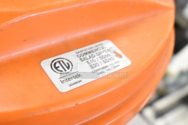 Orange salad spinner with "ETL Intertek" label, featuring model E10/S902. Includes Dynacube vegetable cutter.
