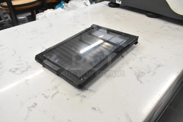 T8 Tablet on countertop, reflective screen, slim black frame, appears in good condition, no visible markings.