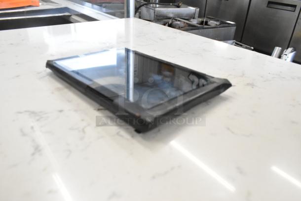 T8 Tablet on a marble surface, showing reflective screen. Edges slightly worn, indicating moderate use.