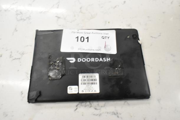 T8 Tablet with visible wear, DoorDash branding, and auction label. Signs of adhesive residue on the back.