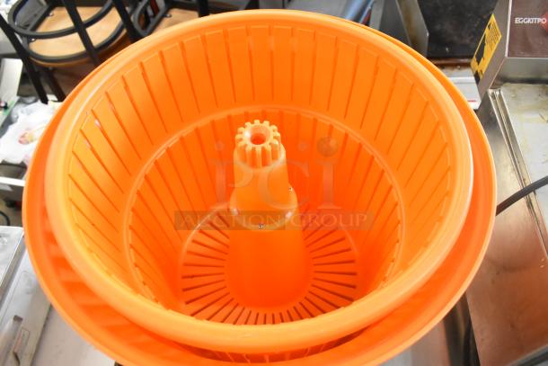 Orange poly lettuce spinner in excellent condition, features a ribbed design and sturdy construction for efficient salad drying.