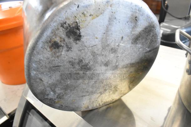 Three metal stock pots with visible wear and scratches, indicating previous use. Durable, multipurpose cooking essentials.