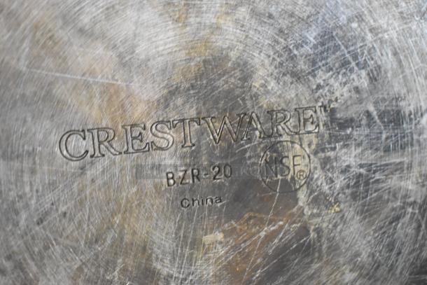 Close-up of metal stock pot base with "Crestware BZR-20" and "NSF" markings, indicating brand and specification. Scratched surface.