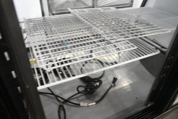 Universal FCI-48 metal deli display case, 115 volts, 1 phase. Wire shelves, interior lighting, visible power cords.