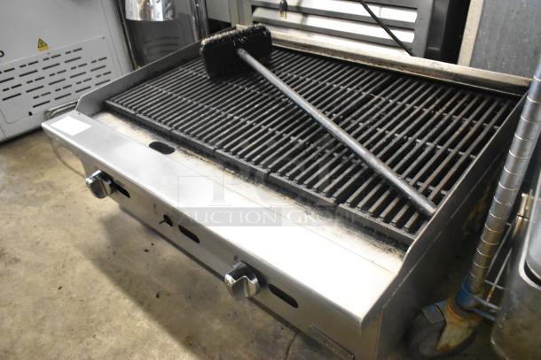 Migali stainless steel countertop gas charbroiler grill in used condition, featuring dual control knobs and grill brush on top.