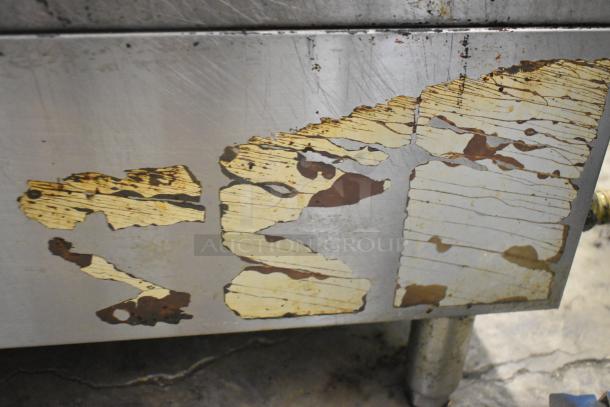 Migali stainless steel charbroiler grill, showing signs of rust and wear, commercial countertop model, gas powered.