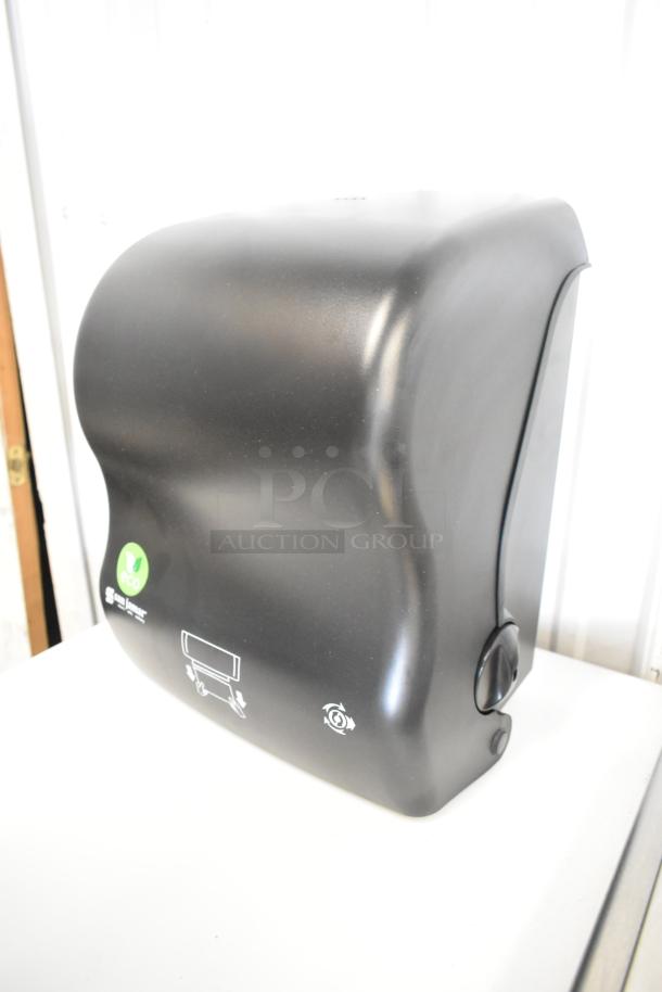 Brand new San Jamar black poly paper towel dispenser, scratch and dent condition, eco-friendly labels visible.