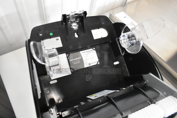 San Jamar black poly paper towel dispenser, brand new with minor scratches, features visible labels and components.
