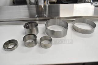 13 brand new Fat Daddio's stainless steel round cake molds, varying sizes, high-quality, durable, minor scratches.