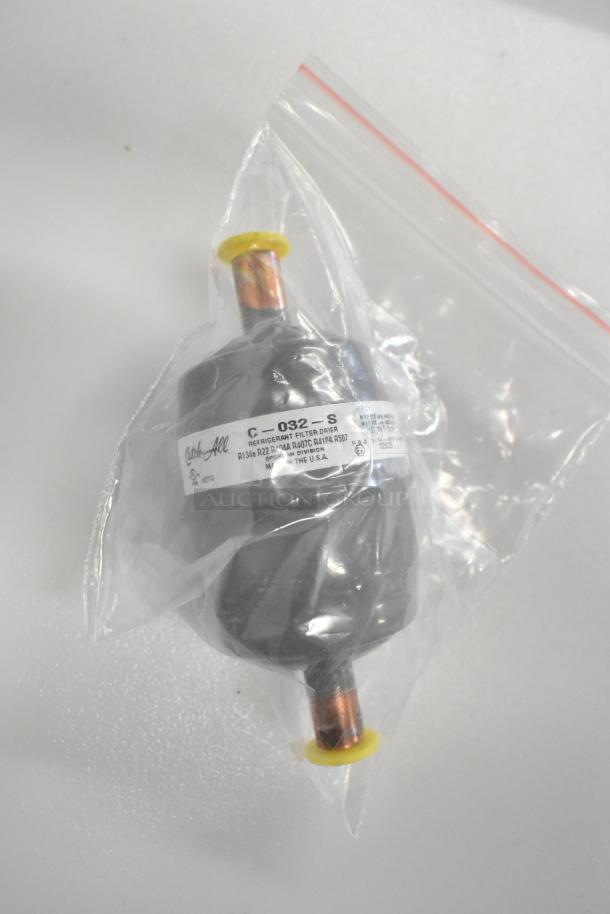 Brand new Catchall C-032 filter drier in plastic packaging, featuring labeling for refrigerant compatibility and origin.