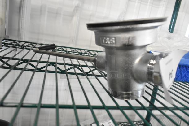 Brand new Choice T&S metal drain with visible scratches, stainless steel finish, threaded connections, and side lever.