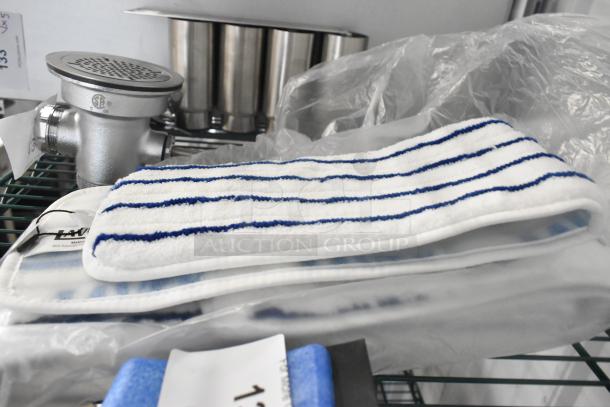 4 new Lavex 24" microfiber mop pads with blue stripes and a blue brush head; scratch and dent condition.