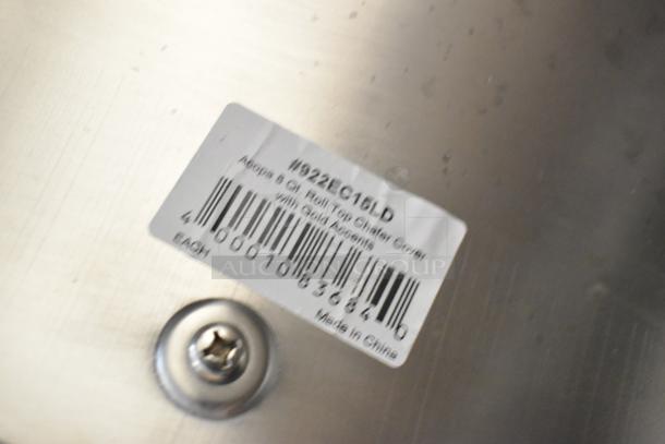Silver surface with barcode label reading "Acopa 8 Qt. Roll Top Chafer Cover with Gold Accents, #922EC16LD, Made in China."