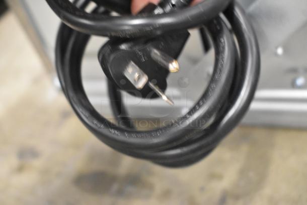 Coiled black power cord with a three-prong plug for the Solwave SWA21T microwave, showing light surface wear.