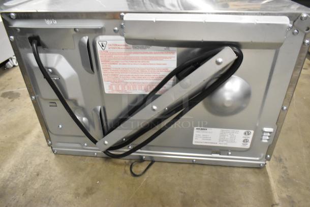 Brand new Solwave SWA21T stainless steel commercial microwave, rear view, showing labels and electrical cord, 208/240V, 1 Phase.