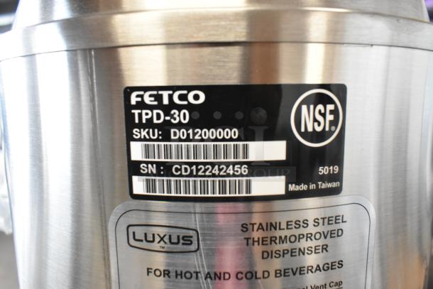 Brand new Fetco TPD-30 Luxus 3-gallon stainless steel coffee dispenser. Visible label with SKU D01200000, SN CD12242456.