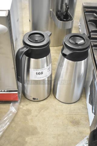 Two QINS SVP-1900A-N stainless steel thermal pitchers, brand new with scratch and dent, featuring black lids. Auction tag visible.