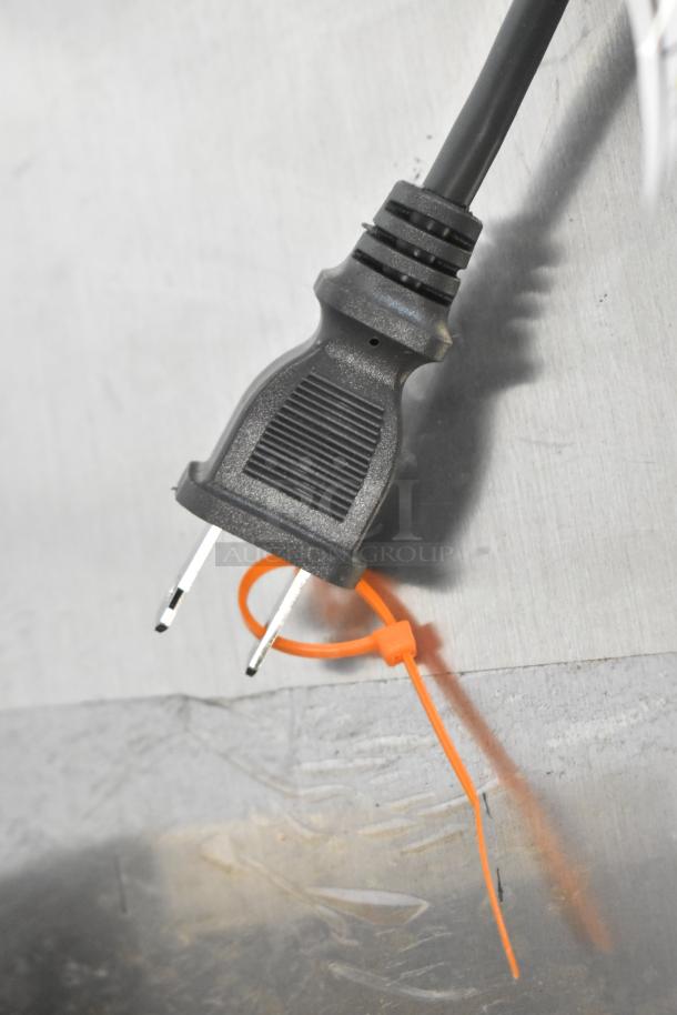 Plug detail of the KitchenAid KHM512ER hand mixer showing the power cord and plug against a metallic surface.