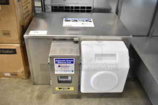 BRAND NEW FM Environment stainless steel 50 lb automatic grease removal unit with visible label and warning tag.