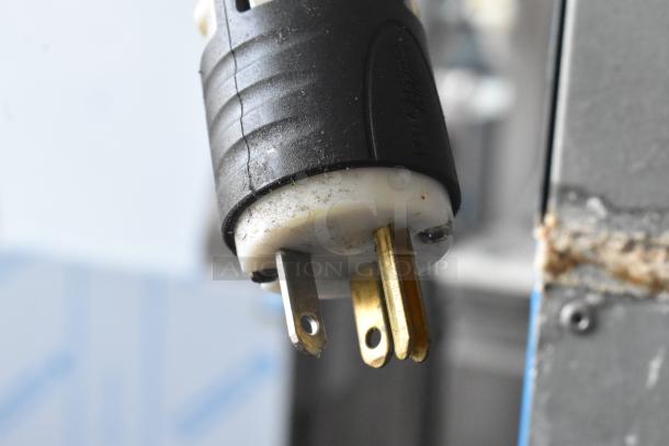 A close-up of a three-prong electrical plug from a Hoshizaki KM-515MA Ice Head, showing slight wear.
