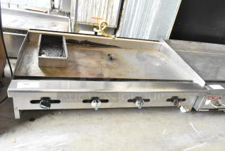 Radiance stainless steel commercial countertop gas griddle with four control knobs. Visible wear on cooking surface. Model 184 tag displayed.