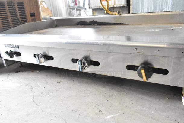 Radiance stainless steel commercial countertop gas griddle, featuring four control knobs, signs of wear, durable construction.