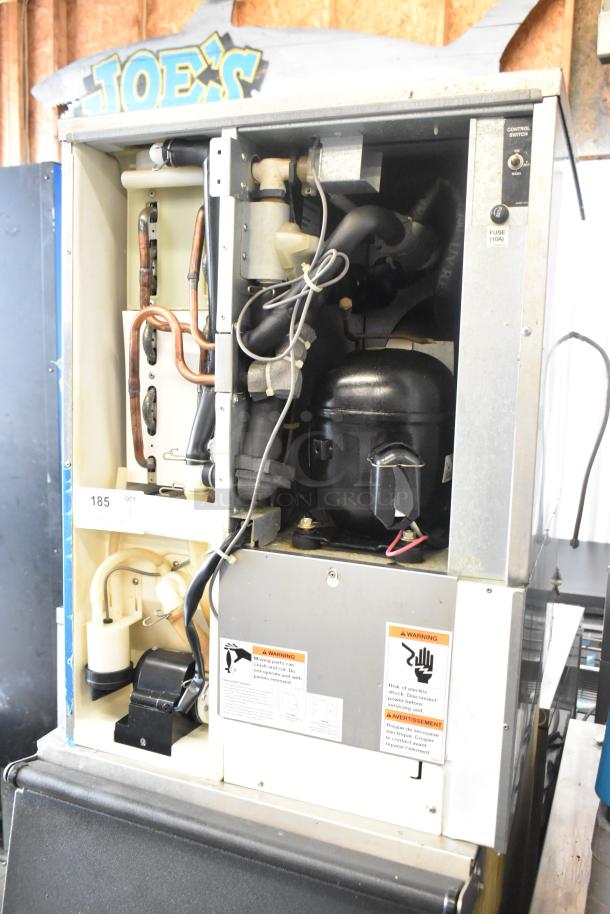 Hoshizaki KM-515MAH stainless steel commercial ice machine head on bin, 115-120V, 1 phase. Visible warning labels and internal components.