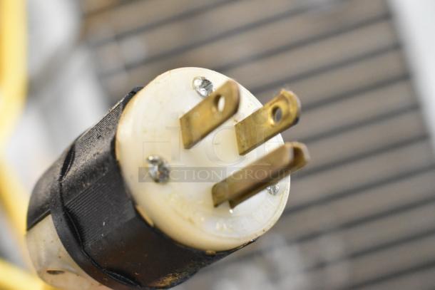 Close-up of a three-prong electrical plug for a Hoshizaki KM-515MAH ice machine, showing metal prongs and black casing.