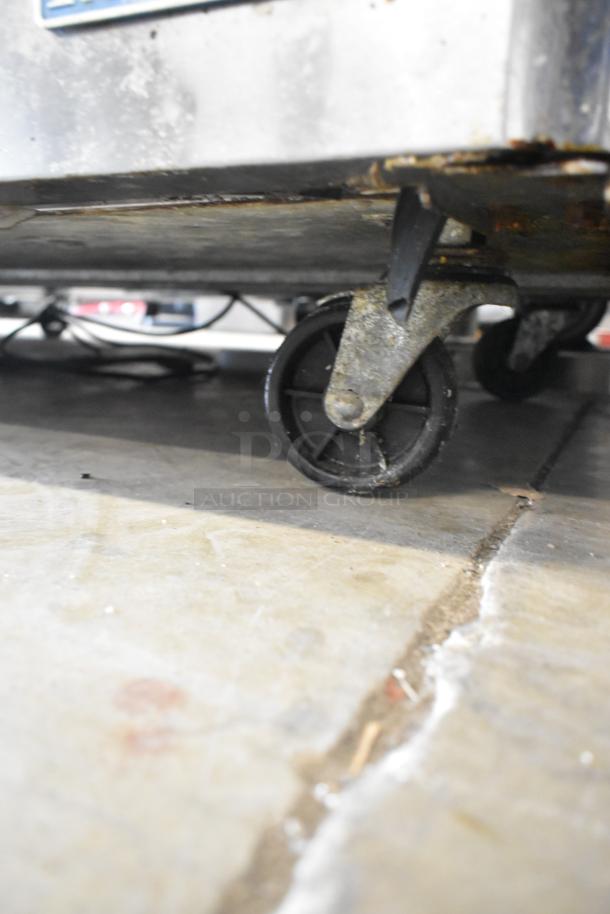 Turbo Air MST-72-30 prep table caster, showing minor rust and wear. Commercial sandwich salad table on wheels.