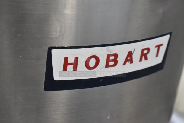 Hobart metal commercial floor-style potato peeler with visible brand label. Sturdy construction, suitable for heavy-duty use.