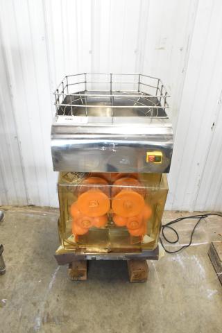 Stainless steel commercial countertop citrus juicer with cage, visible power switch; 115 volts, 1 phase.