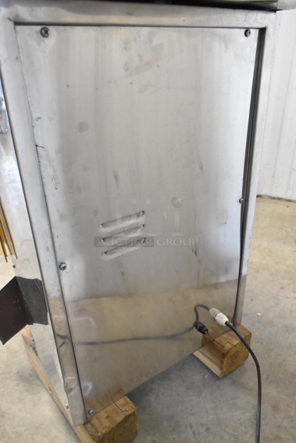 Stainless steel commercial countertop citrus juicer, 115 volts, 1 phase, visible wear, vented panel, electrical cord attached.