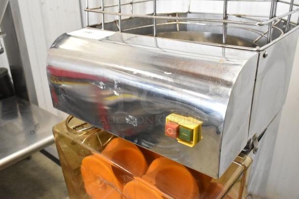 Stainless steel commercial countertop citrus juicer, 115 volts, 1 phase, showing power switch and some surface wear.