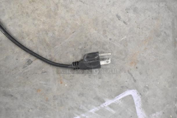Close-up of a power plug for a stainless steel commercial countertop citrus juicer, 115 volts, 1 phase.