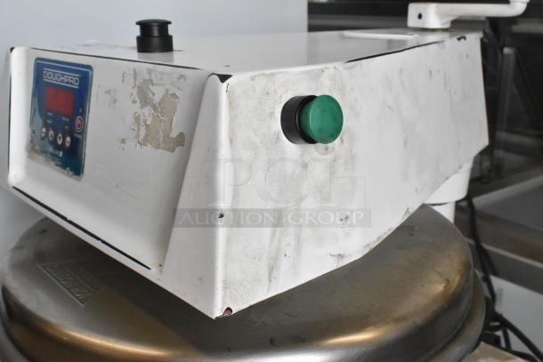 DoughPro metal commercial countertop dough press on equipment stand; shows wear and labels, operates at 115 volts, 1 phase.