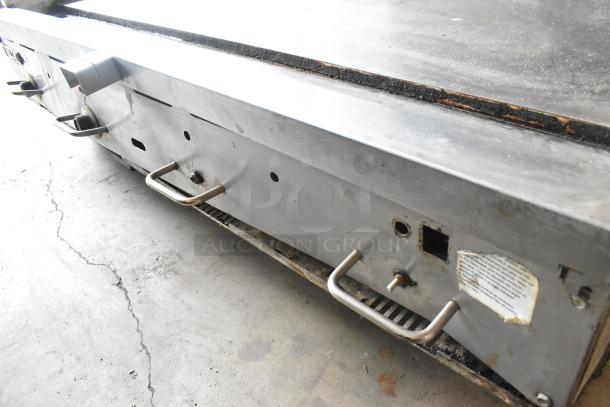 Stainless steel Vulcan 48RPG-E commercial griddle, natural gas-powered, flat top, visible wear, with control knobs and label.