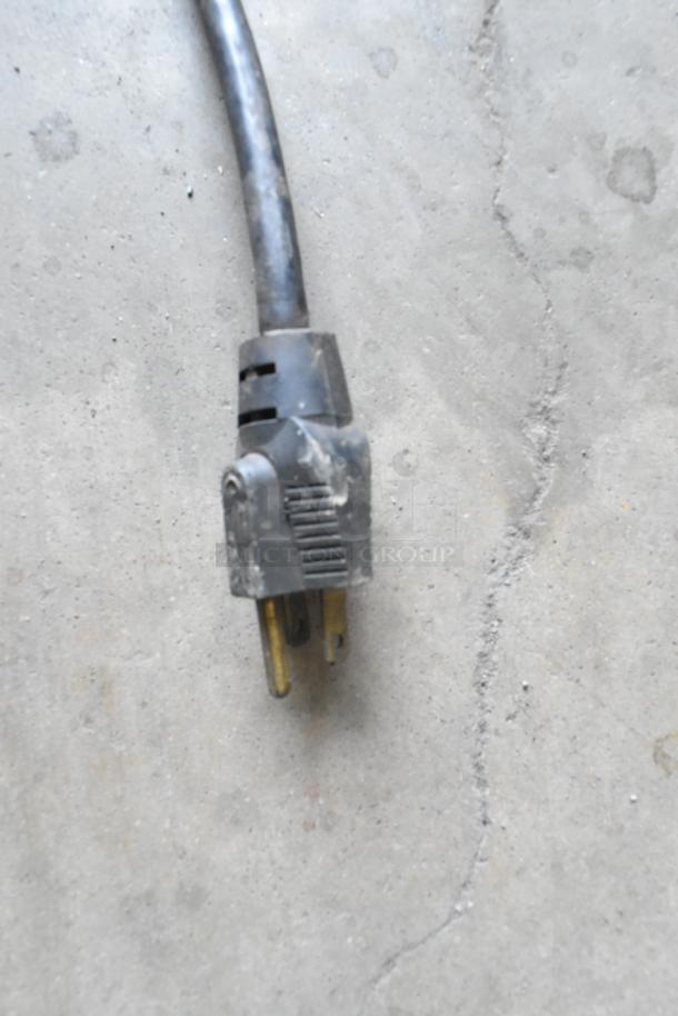 Close-up image of a black power plug belonging to the Taylor 450-12 frozen beverage machine, showing a standard three-prong connector.