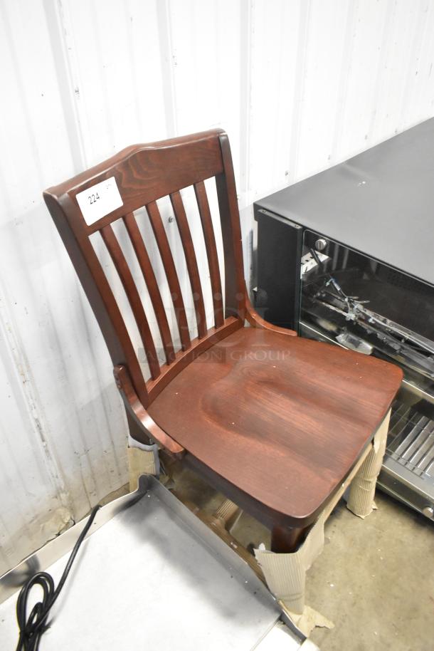 Brand new wooden dining chair with minor scratches. Features a slatted backrest and dark finish. Tag number 224 visible.