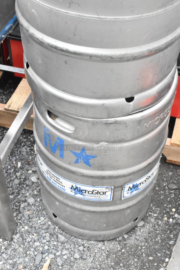 Two metal half-barrel kegs by MicroStar, visible wear, "M" and star markings, ideal for brewing or storage.