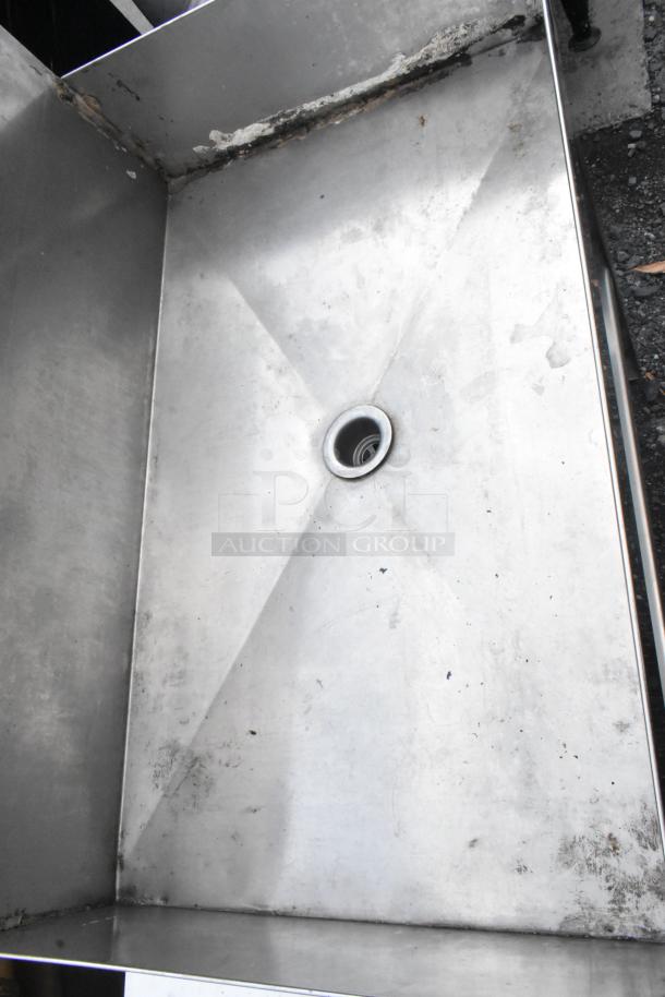 Metal Ice Bin Table with drainage hole. Shows signs of wear and discoloration. Ideal for cooling beverages.